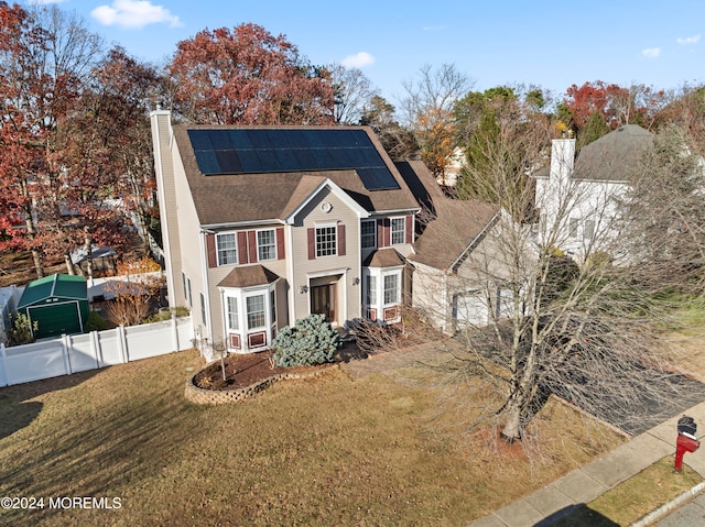 view of front of home featuring a front yard and solar panels