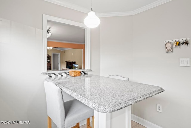 kitchen with a kitchen breakfast bar, kitchen peninsula, hanging light fixtures, and crown molding