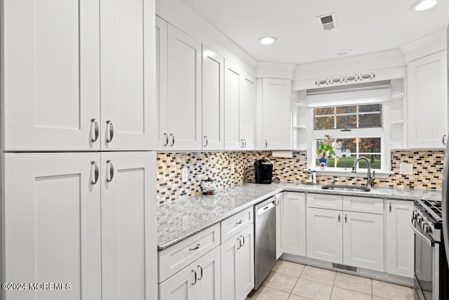 kitchen with sink, white cabinetry, light stone counters, and stainless steel appliances