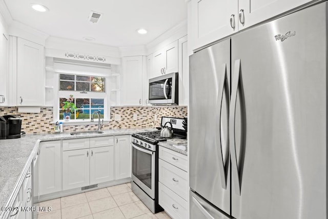 kitchen with white cabinetry, tasteful backsplash, appliances with stainless steel finishes, and sink