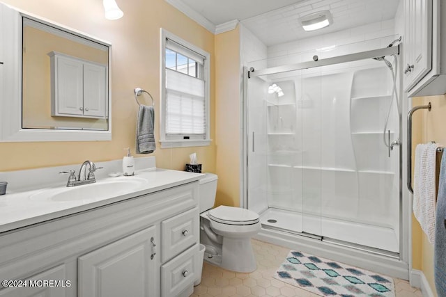 bathroom featuring vanity, toilet, ornamental molding, and a shower with shower door