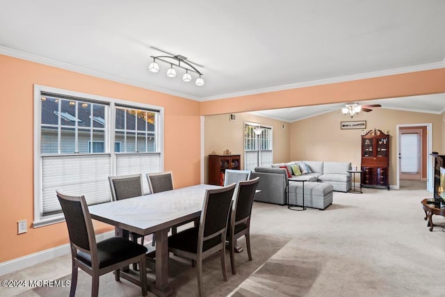 dining room with ornamental molding, light carpet, and ceiling fan