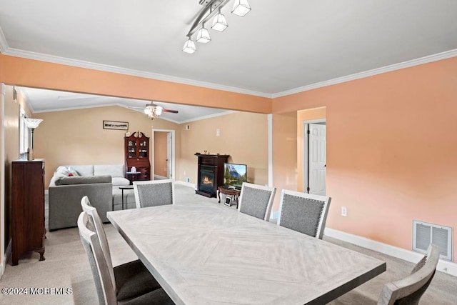 carpeted dining area with crown molding and ceiling fan