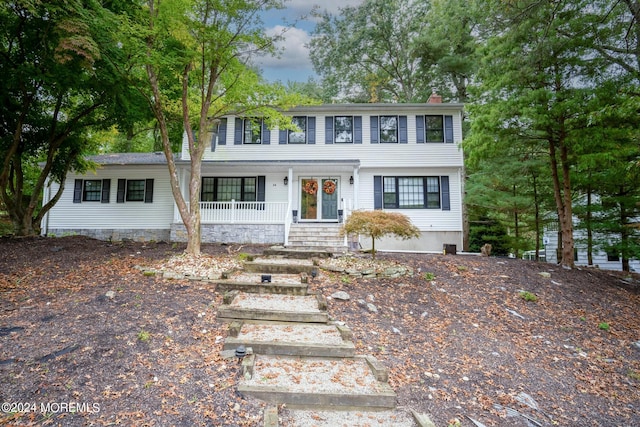 colonial-style house featuring covered porch