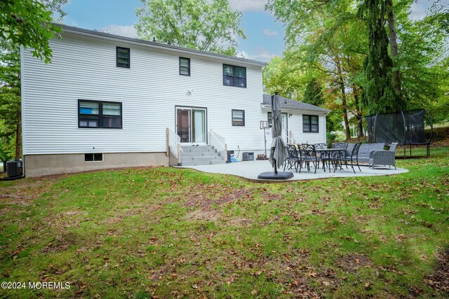 rear view of house with a patio, a lawn, a trampoline, and central air condition unit