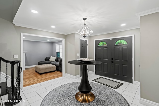 entrance foyer with an inviting chandelier, ornamental molding, and light tile patterned floors