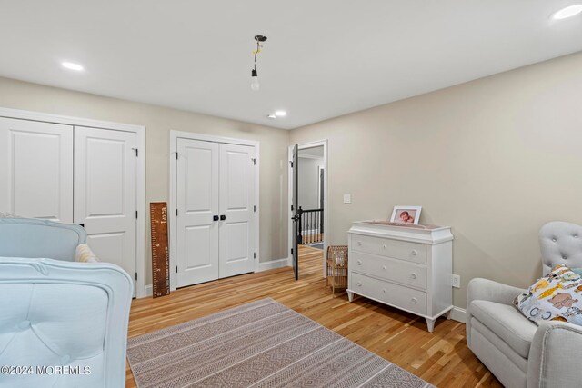 bedroom featuring light hardwood / wood-style flooring and multiple closets