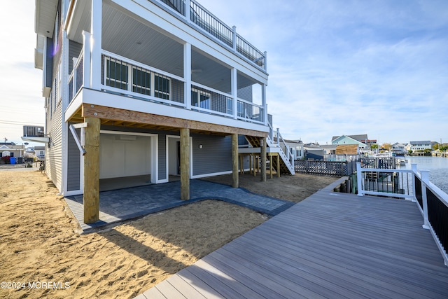 back of property with a patio, central AC unit, and a water view