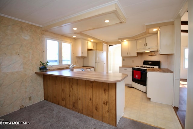 kitchen with light carpet, kitchen peninsula, ornamental molding, white cabinetry, and white appliances