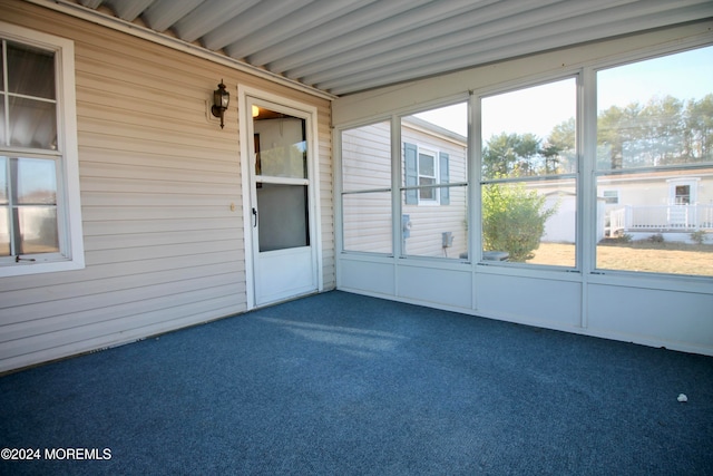 unfurnished sunroom with a wealth of natural light and beamed ceiling