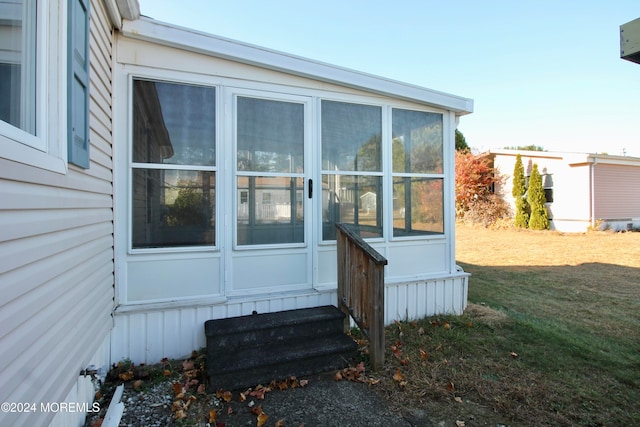 view of property exterior featuring a yard and a sunroom