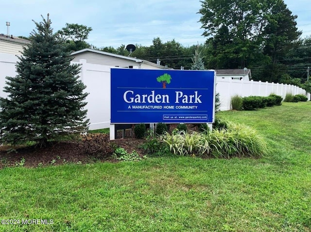 community sign featuring a yard and fence