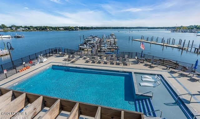 view of swimming pool featuring a patio area and a water view