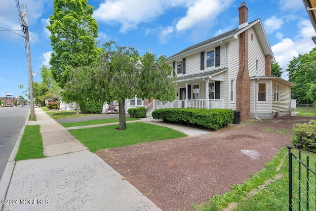 view of front of home featuring a front yard and covered porch