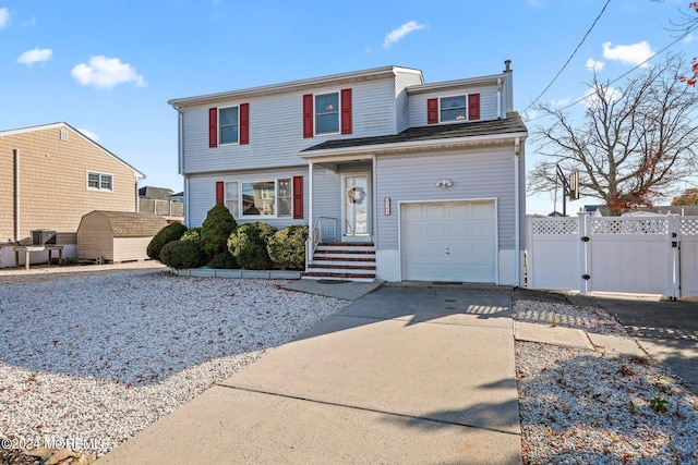 view of front of house featuring driveway, a gate, fence, central AC unit, and a garage