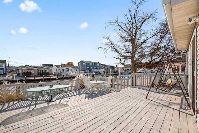 wooden terrace featuring a residential view and outdoor dining area