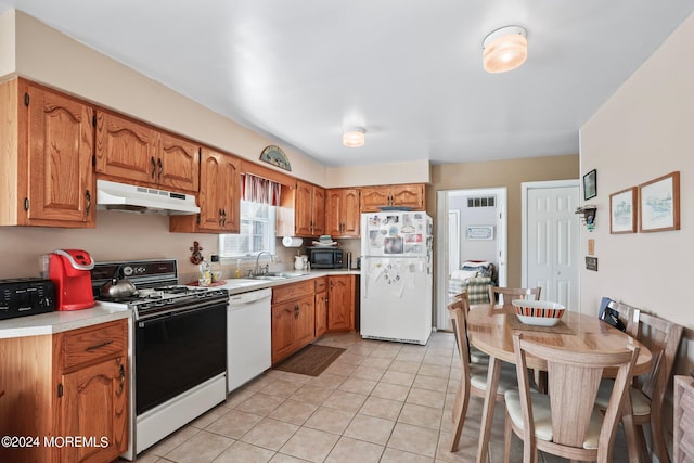 kitchen with sink, light tile patterned floors, and white appliances