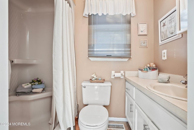 bathroom featuring a shower with curtain, toilet, vanity, baseboards, and visible vents