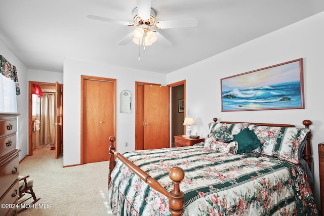 carpeted bedroom featuring two closets and ceiling fan