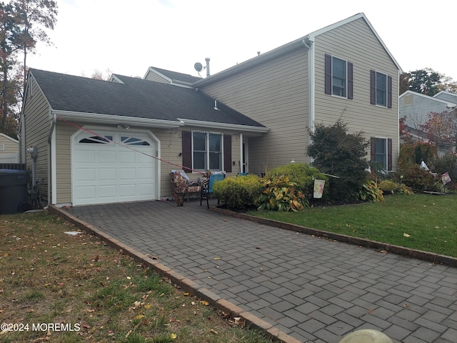 view of front of property featuring a garage and a front lawn