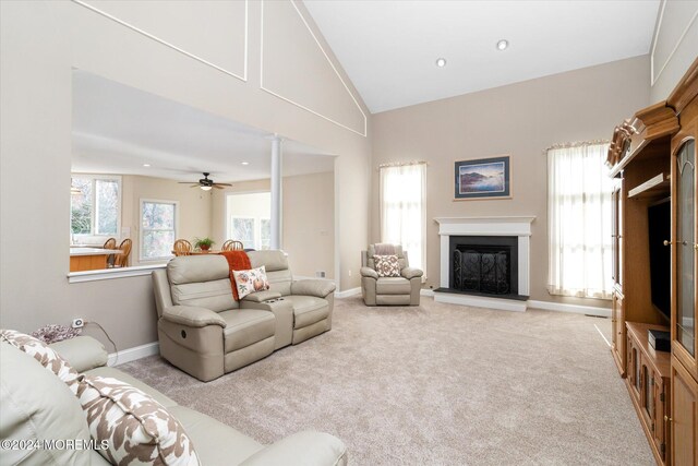 living room with ceiling fan, light carpet, lofted ceiling, and decorative columns