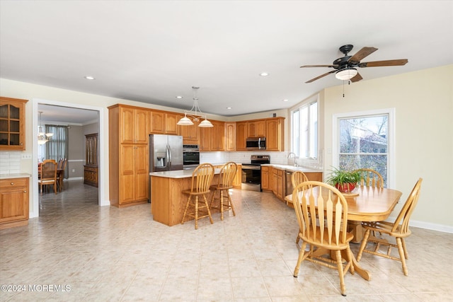 tiled dining area with ceiling fan with notable chandelier and sink