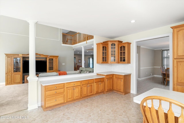 kitchen featuring light carpet, backsplash, crown molding, and decorative columns