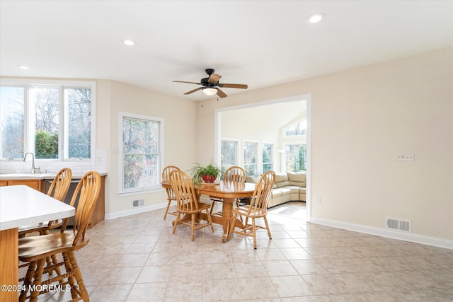 tiled dining room featuring ceiling fan and sink