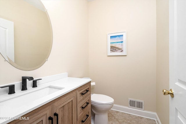 bathroom with tile patterned flooring, vanity, and toilet