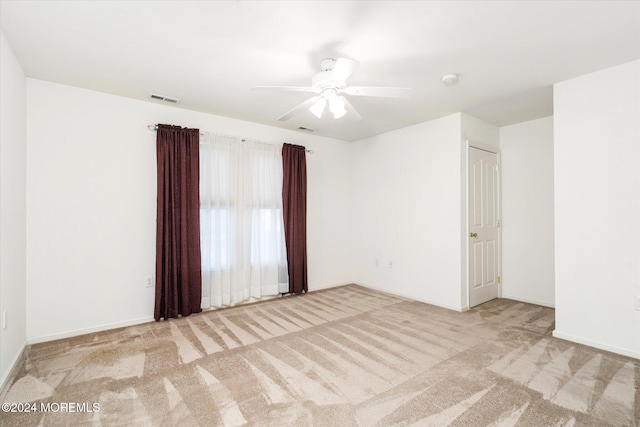 spare room featuring light carpet and ceiling fan