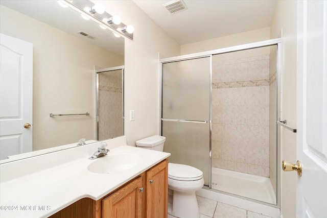 bathroom with vanity, tile patterned flooring, toilet, and an enclosed shower