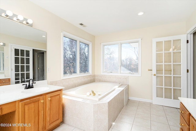 bathroom featuring tiled bath, vanity, and tile patterned floors