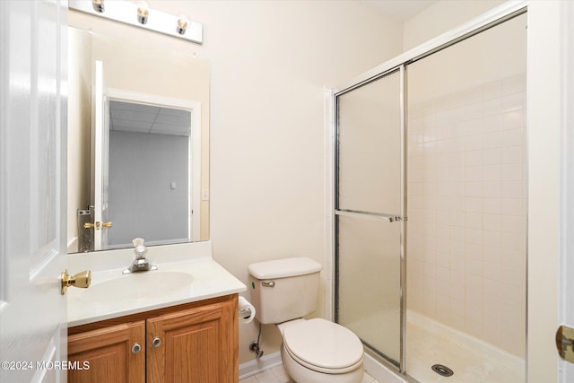 bathroom with tile patterned flooring, vanity, toilet, and a shower with shower door