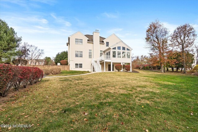 24 Clearwater Dr, Allentown, NJ 08501 - rear view of property featuring a sunroom, a chimney, a yard, and stairs