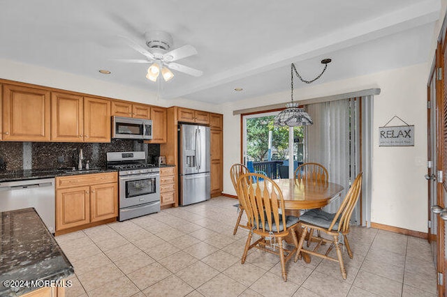 kitchen with hanging light fixtures, dark stone counters, tasteful backsplash, appliances with stainless steel finishes, and ceiling fan