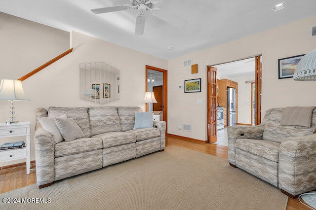 living room with wood-type flooring and ceiling fan