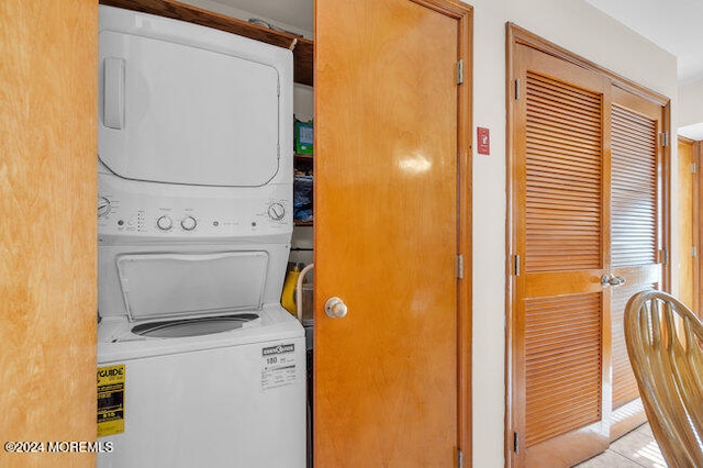 laundry room featuring stacked washer / drying machine