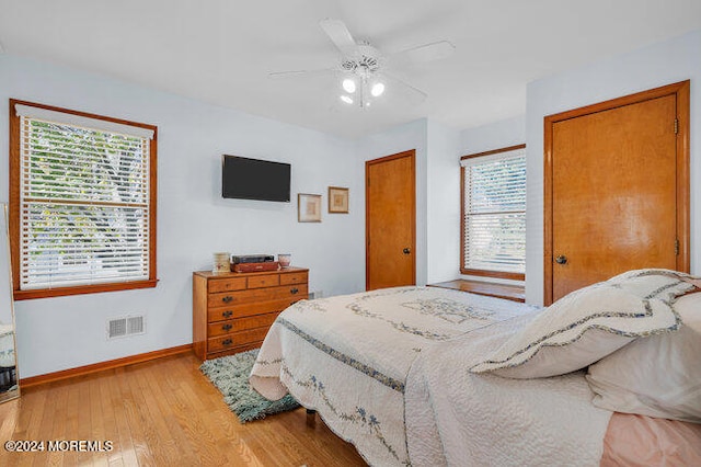 bedroom with multiple windows, light wood-type flooring, and ceiling fan