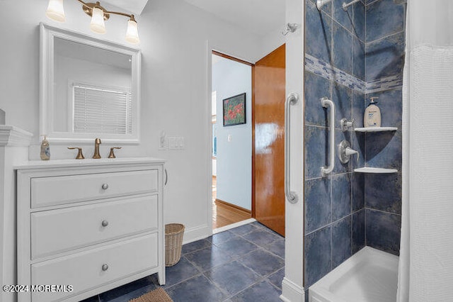 bathroom featuring vanity, tile patterned floors, and tiled shower