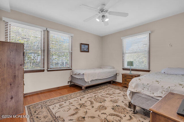 bedroom featuring light hardwood / wood-style flooring, multiple windows, and ceiling fan