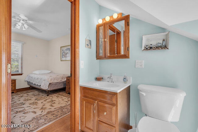 bathroom featuring toilet, hardwood / wood-style flooring, vanity, and ceiling fan