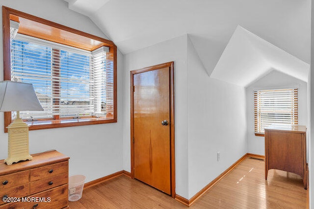 bedroom featuring light hardwood / wood-style floors and lofted ceiling