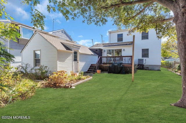 back of property with a deck and a lawn