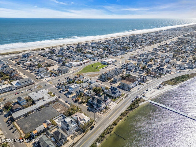 birds eye view of property with a water view and a beach view