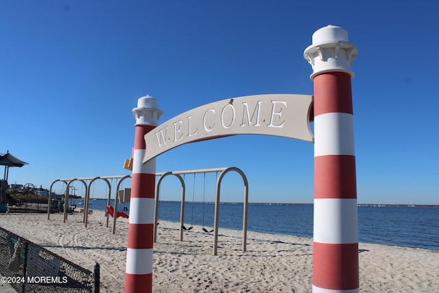 surrounding community with a water view and a view of the beach