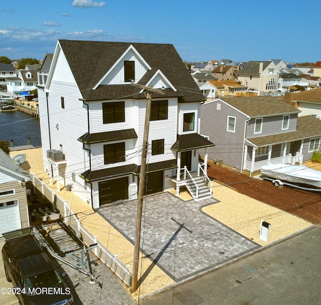 view of front of property with a water view and central AC unit