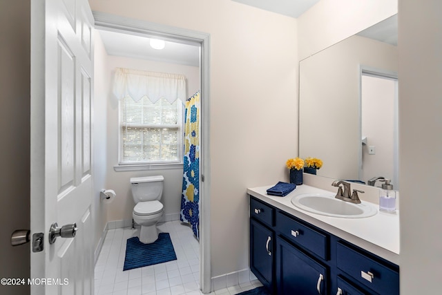 bathroom with toilet, vanity, and tile patterned flooring