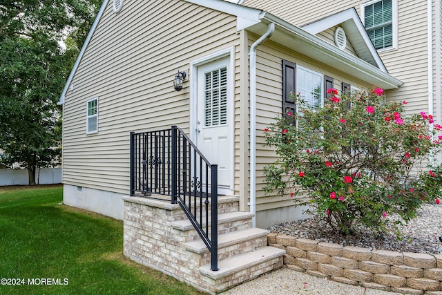 view of exterior entry with a lawn