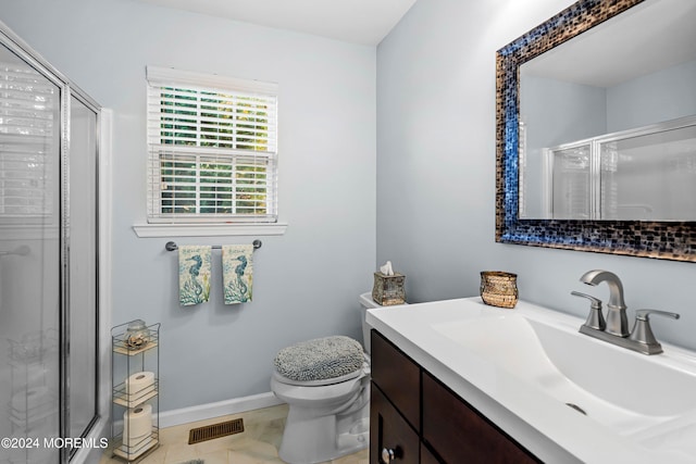 bathroom featuring tile patterned floors, toilet, a shower with door, and vanity