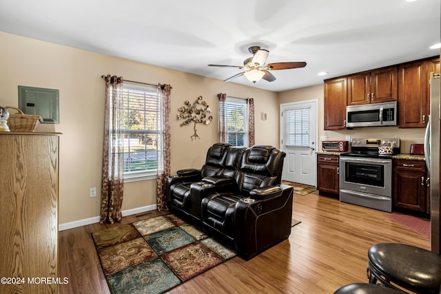 living room with ceiling fan and light hardwood / wood-style flooring